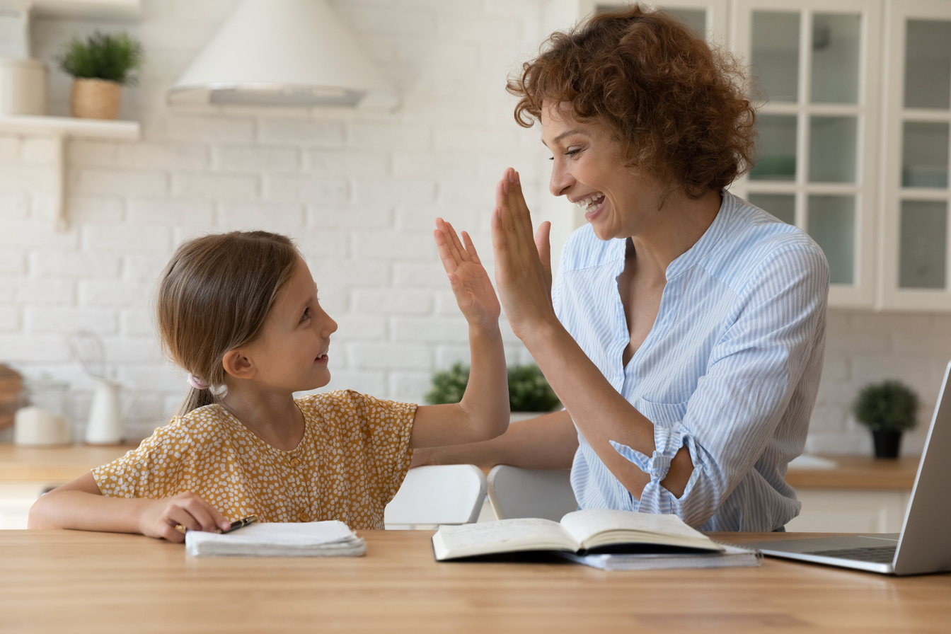 Excited mother give high five to small daughter praise child