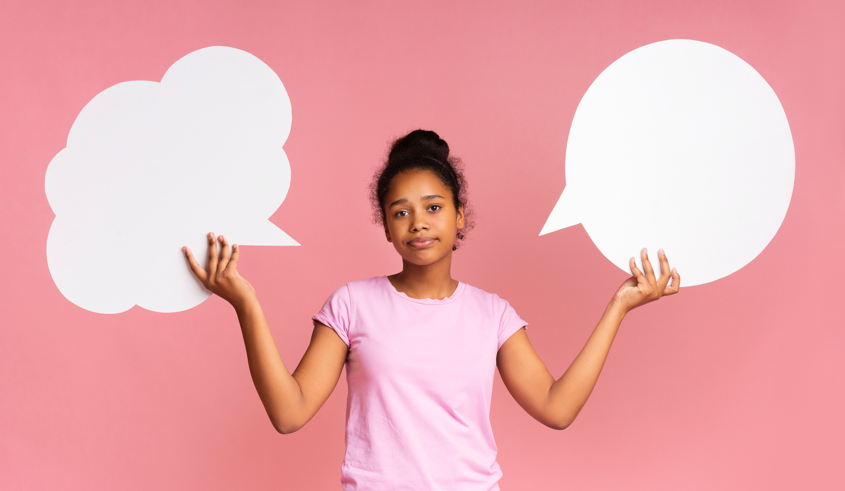 Teen girl having complex choice holding two speech bubbles